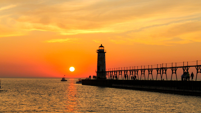Une jetée et un phare au coucher du soleil à South Haven, Michigan.