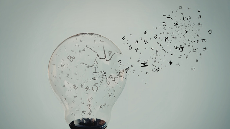 Des symboles mathématiques semblent sortir d’une ampoule brisée.