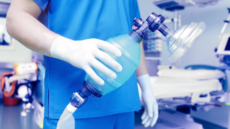 Professionnel de la santé tenant un appareil respiratoire pour la réanimation