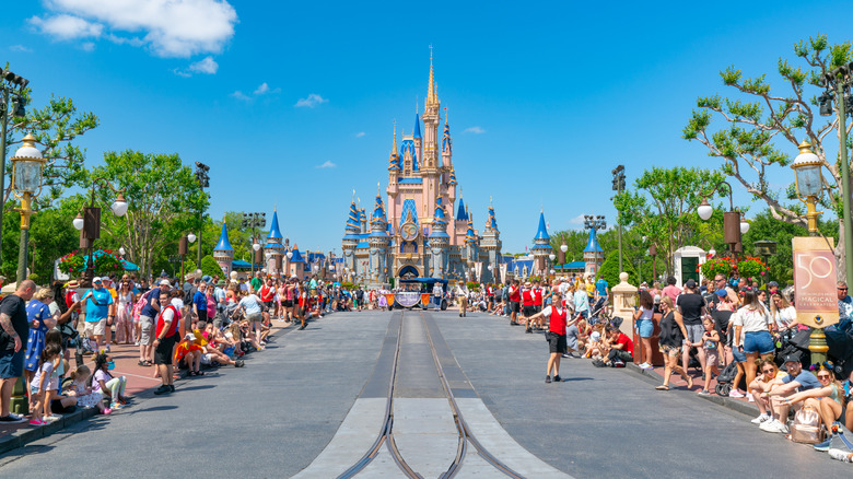 Des foules se sont rassemblées le long de la rue de parade vide, avec le château de Cendrillon en vue.