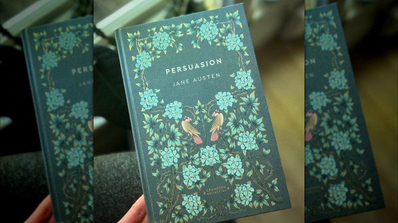 Une main tenant un exemplaire de « Persuasion » de Jane Austen