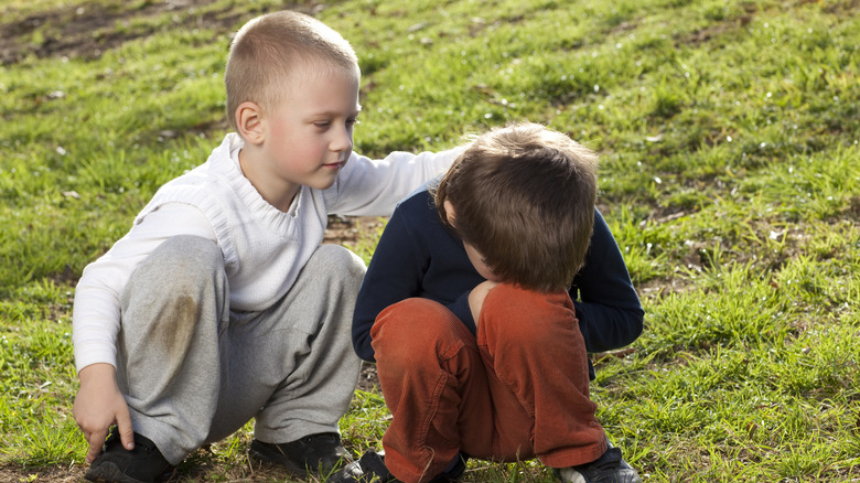 un enfant pleure avec un ami qui le réconforte