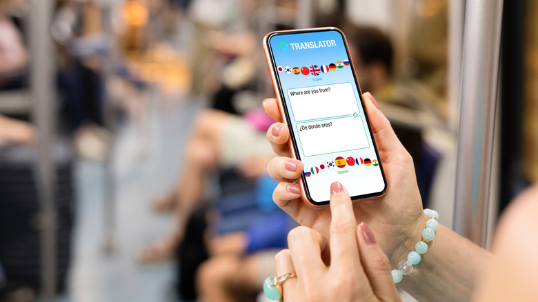 les mains d'une femme tenant un téléphone avec une application de traduction