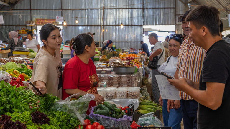 les étrangers sur un marché local essaient de communiquer dans une autre langue