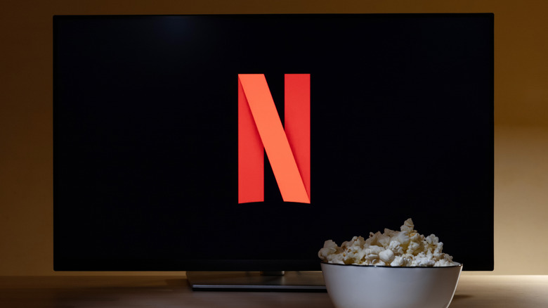 Une télévision avec le symbole Netflix et un bol blanc de pop-corn posé devant