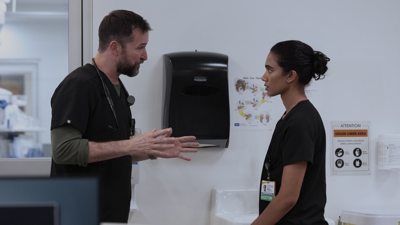Robby parle sévèrement à Mohan dans une salle d'examen sur The Pitt
