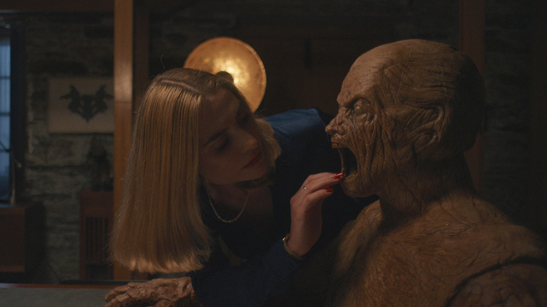 Yana touchant la bouche du golem dans Oddity