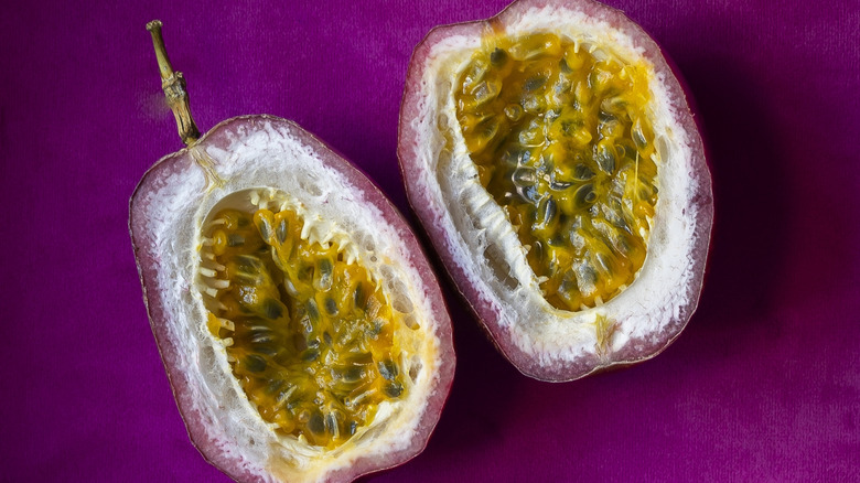 Deux moitiés de fruit de la passion coupées sur velours rose