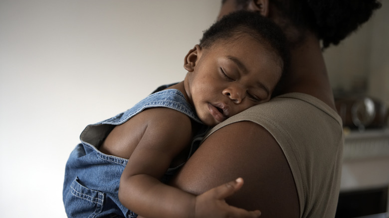 Mère tenant son bébé pendant qu'il dort sur son épaule