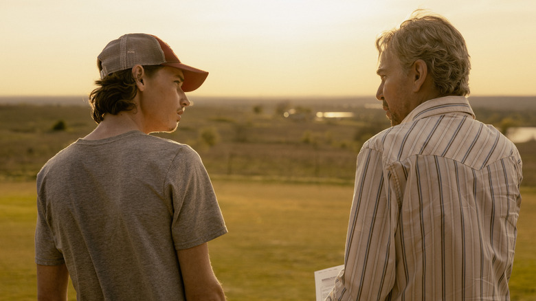 Cooper Norris de Jacob Lofland et Tommy Norris de Billy Bob Thornton sont vus de derrière alors qu'ils se tiennent côte à côte à l'extérieur à Landman