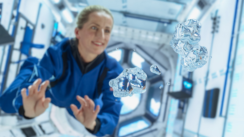 Astronaute en apesanteur avec des gouttes d'eau flottant autour de sa tête