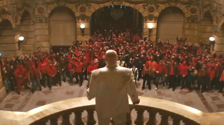 Vincent D'Onofrio dans le rôle de Wilson Fisk debout sur un balcon surplombant une foule de manifestants en colère dans Daredevil : Born Again