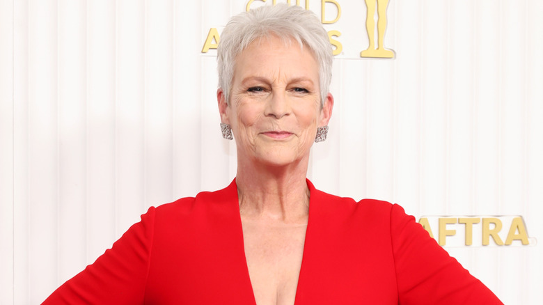 Jamie Lee Curtis porte une robe rouge décolletée sur le tapis rouge