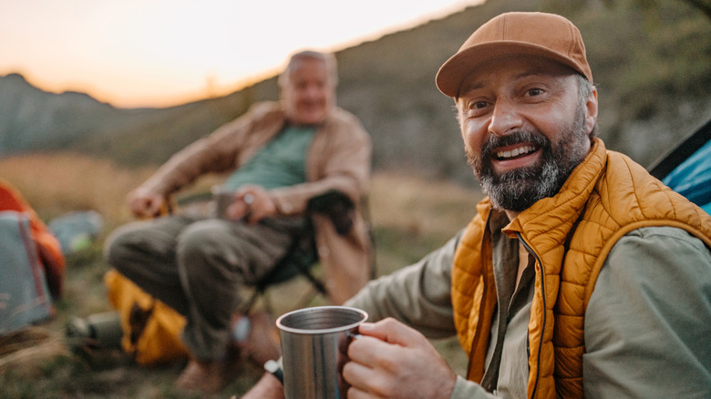 hommes buvant du café au camp
