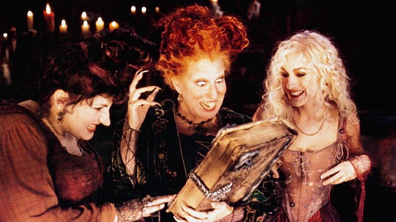 Kathy Najimy, Bette Midler et Sarah Jessica Parker regardant leur livre de sorts dans Hocus Pocus