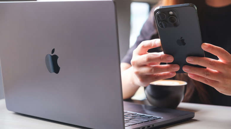 personne utilisant un iPhone 15 et un MacBook