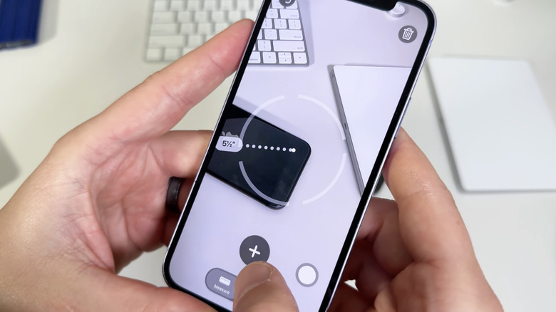 homme utilisant l'application de mesure iPhone