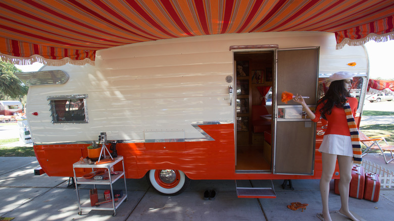 Un camping Shasta aménagé avec un auvent rouge.