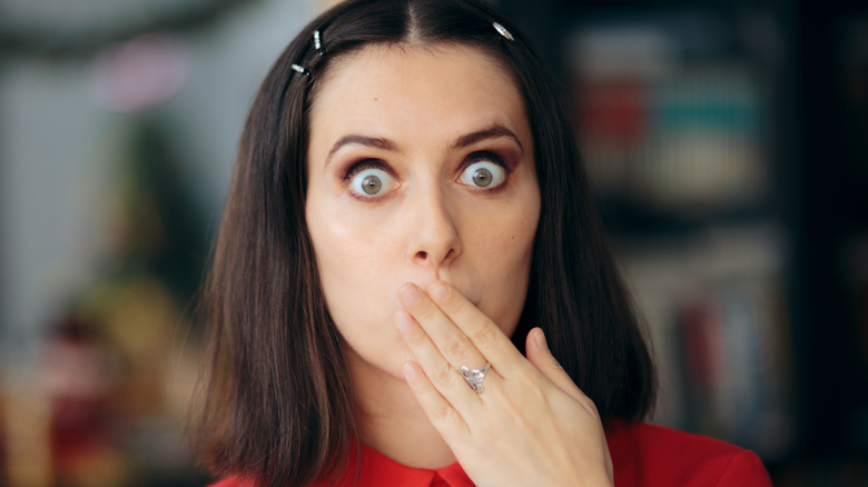 Femme tenant une main sur sa bouche