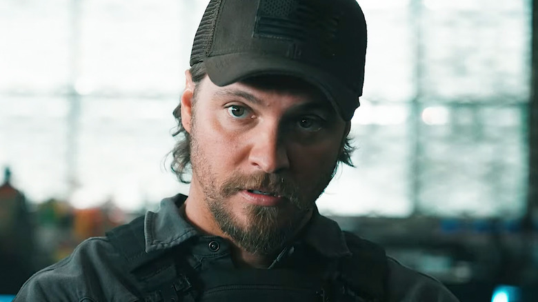 Kayce Dutton de Luke Grimes regarde à travers le cadre alors qu'il se tient dans une armurerie dans Marshals
