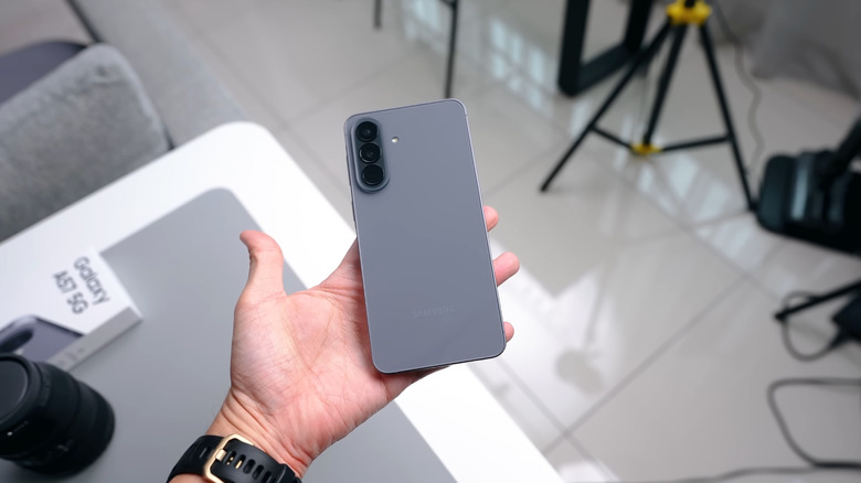 Une personne tenant le Samsung Galaxy A57 5G dans le coloris Gris