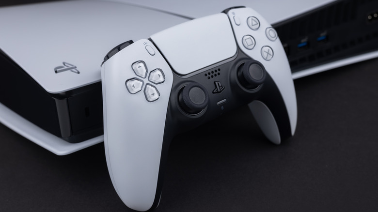 Une manette PlayStation 5 reposant sur une console PlayStation 5.