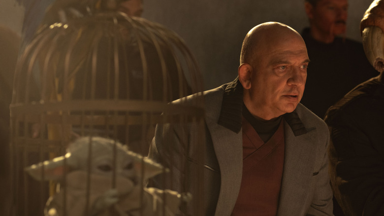 Lord Janu regarde Rotta et Mando se battre avec Grogu dans une cage à ses côtés dans The Mandalorian and Grogu