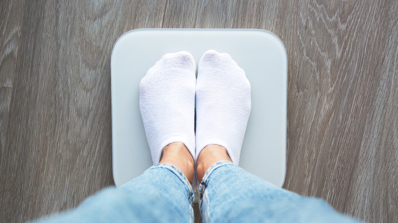 Un gros plan d’une personne debout sur une balance.