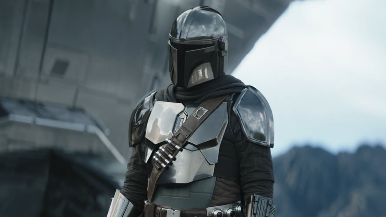 Mando debout près de son nouveau Razor Crest dans The Mandalorian et Grogu