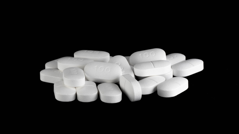 Un tas de pilules blanches sur fond noir.