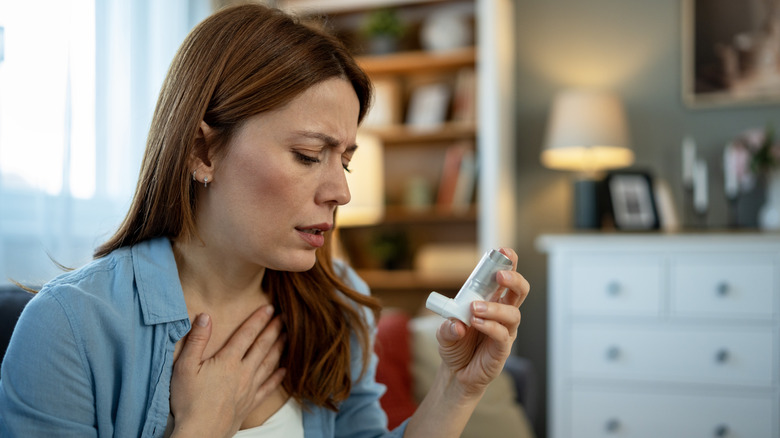 Femme ayant des difficultés respiratoires tenant un inhalateur