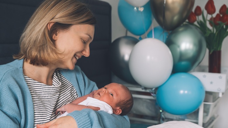 Une femme berce son fils nouveau-né.