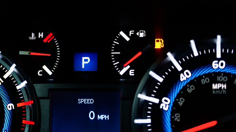 Tableau de bord de voiture éclairé montrant la jauge de carburant presque vide