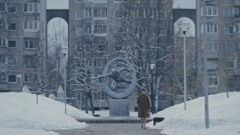 Agnes O'Casey dans le rôle d'Irina Morozova marchant sur une place enneigée devant une statue soviétique à la Cité des étoiles