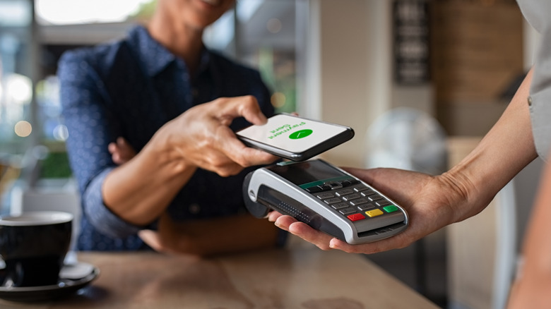 Personne payant sa facture via un smartphone utilisant la technologie NFC