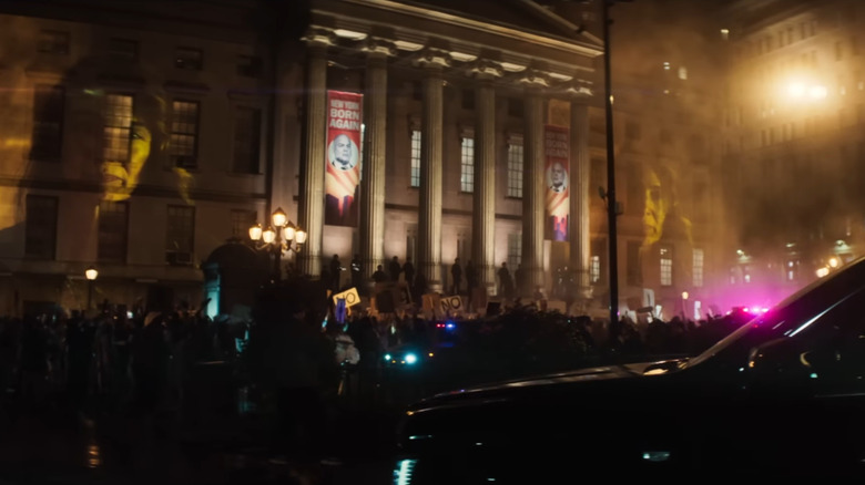 Plan d'ensemble d'un palais de justice de New York entouré d'officiers armés et d'un groupe de manifestants dans Daredevil : Born Again