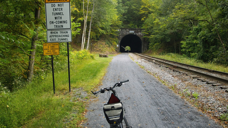 Vélo garé près d'un panneau d'avertissement à l'approche d'un tunnel sur le sentier récréatif Great Allegheny Passage