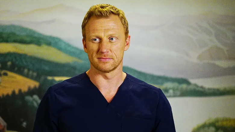 Owen debout devant un tableau en blouse sur Grey's Anatomy