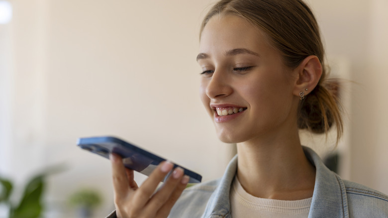 Une personne souriante en tenant un smartphone