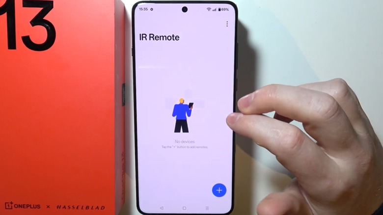 Une personne utilisant un téléphone OnePlus 13 affichant la fonction de télécommande infrarouge