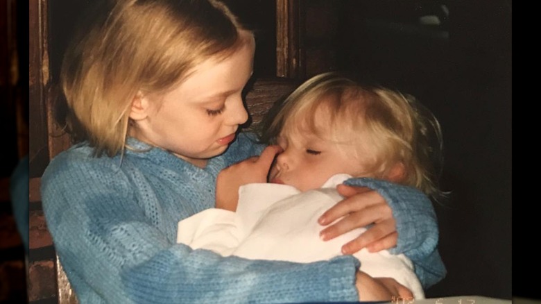 La jeune Dakota Fanning tient dans ses bras une petite fille endormie, Elle Fanning.