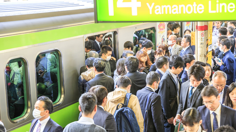 Foule de navetteurs montant et descendant d'un train aux heures de pointe à la gare de Shinjuku.