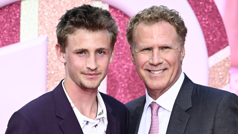 Will Ferrell posant avec son fils Magnus lors d'un événement sur le tapis rouge sur fond rose scintillant.