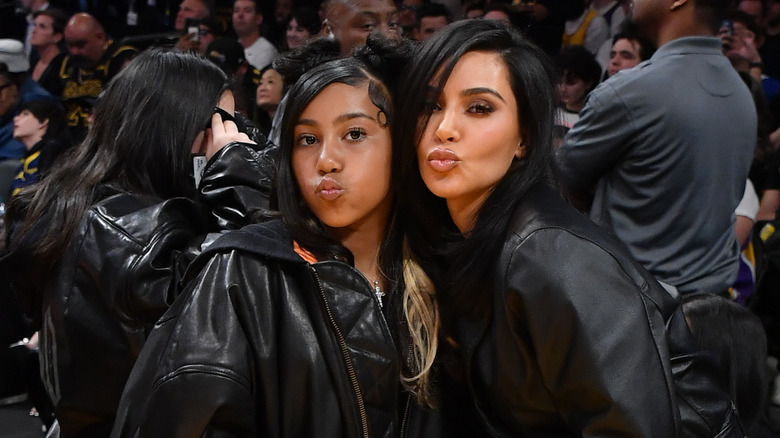 North West posant avec sa mère Kim Kardashian faisant des grimaces tout en portant des tenues entièrement noires.