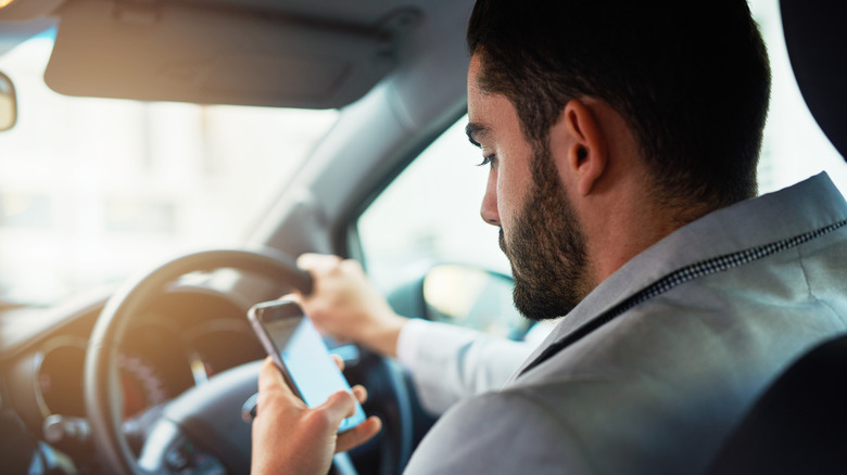 Aman utilise son téléphone en conduisant