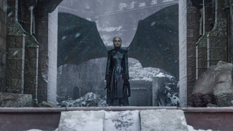 Game of Thrones - Daenerys dans les ruines de King's Landing avec les ailes de Drogon derrière elle