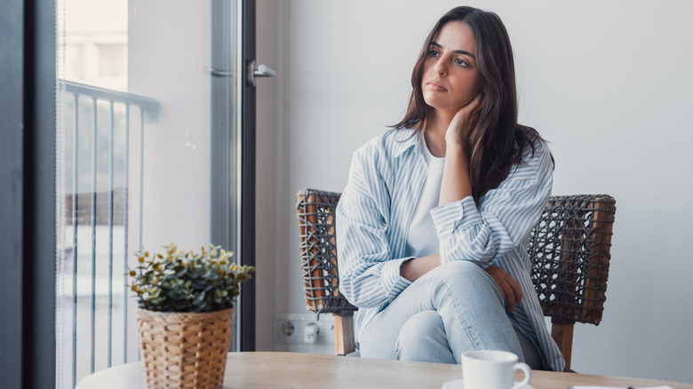 Femme assise sur une chaise avec une expression apathique