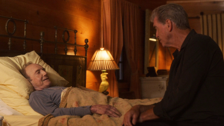 Stan Mullen de James Caan est allongé dans son lit tandis que Charlie Swift de Pierce Brosnan est assis sur le bord dans Fast Charlie
