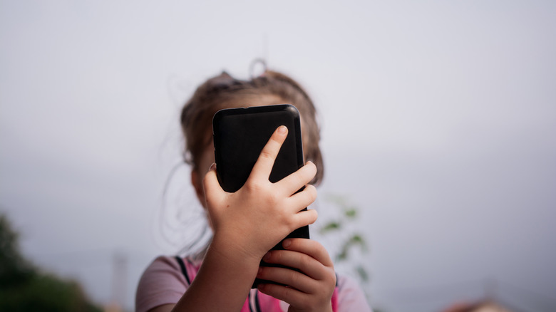 Un jeune enfant utilisant un smartphone.