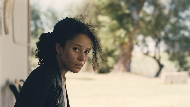 Willa regardant par-dessus son épaule, effrayée dans One Battle After Another